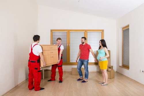 Movers carrying furniture through a Swiss Cottage apartment building